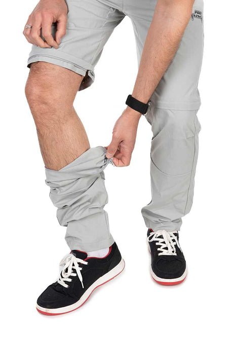 Pantalón desmontable Fox Rage gris claro, modelo Zip-Off, siendo ajustados por un usuario.